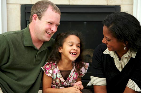 Men and women smiling with child